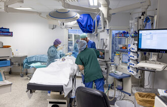 Bildet viser sykepleiere som gjør klar en operasjonsstue.