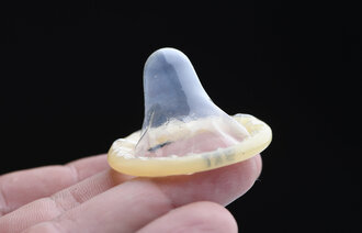 Bilde viser en hånd som viser frem en kondom