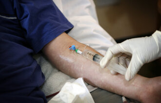 Bildet viser en sykepleier som gir intravenøs antibiotika til en pasient.