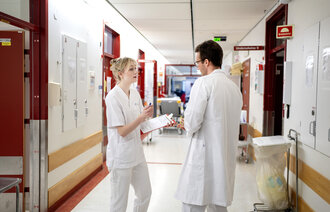 Bildet viser en sykepleier og en lege som snakker sammen.