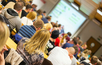 Bildet viser en gruppe studenter som sitter i en forelesningssal