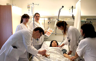 Bildet viser helsepersonell rundt en pasientseng.