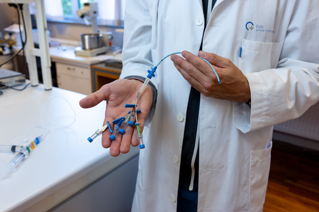Bildet viser hender som holder utstyr til å gi infusjoner.