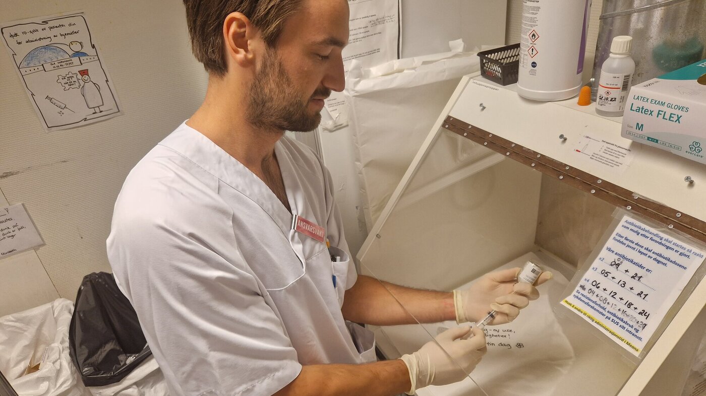 Sykepleier klargjør en sprøyte med antibiotika En mannlig sykepleier klargjør en sprøyte med antibiotika.