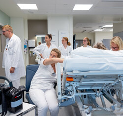 bildet viser mange helsepersonell rundt en pasient