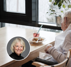 Bildet viser en sykepleier og en eldre kvinne ved matbordet på en helseinstitusjon.
